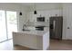 Modern kitchen with stainless steel appliances, white cabinets, island and pendant lights at 2438 Sw 165Th Street Rd, Ocala, FL 34473