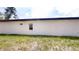 View of the side of a white single-story house, grass, and a few trees at 2438 Sw 165Th Street Rd, Ocala, FL 34473
