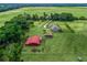 Aerial view of an estate featuring a home, barn, and expansive pastures, offering a serene countryside setting at 2540 Ne 120Th St, Anthony, FL 32617