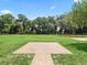 Expansive backyard showcasing a stone patio area, lush greenery, mature trees, and fencing at 2540 Ne 120Th St, Anthony, FL 32617