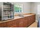 Counter area with plentiful cabinets, a stainless sink under a window, and a built-in wine fridge at 2540 Ne 120Th St, Anthony, FL 32617