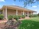Inviting home exterior featuring a wide covered porch, manicured landscaping, and mature trees at 2540 Ne 120Th St, Anthony, FL 32617
