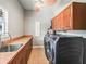 Functional laundry room featuring a sink, ample cabinet space, and modern washer and dryer units at 2540 Ne 120Th St, Anthony, FL 32617