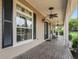 Covered porch features detailed trim, ceiling fans, and views of the property's meticulously kept yard at 2540 Ne 120Th St, Anthony, FL 32617