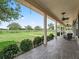 Inviting covered porch featuring decorative ceiling fans, outdoor seating and views of the expansive green pasture at 2540 Ne 120Th St, Anthony, FL 32617
