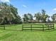 Picture of a large yard, green grass, wooden fence and mature trees at 2540 Ne 120Th St, Anthony, FL 32617
