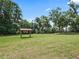 Picture of a large yard with a shade structure with mature trees in the background at 2540 Ne 120Th St, Anthony, FL 32617