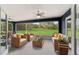 Comfortable screened lanai with wicker furniture, ceiling fan, and expansive views of the green lawn at 37 Water Track Dr, Ocala, FL 34472