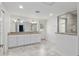 Bathroom with double vanity, granite counters, white cabinets and tiled floor at 4010 Sw 7Th Avenue Rd, Ocala, FL 34471