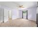 Large bedroom featuring neutral colored carpet, ceiling fan, and a door that leads to the hallway at 4010 Sw 7Th Avenue Rd, Ocala, FL 34471