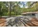 Large driveway leading to a well-maintained ranch-style home surrounded by mature trees at 4010 Sw 7Th Avenue Rd, Ocala, FL 34471