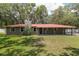 Charming ranch-style home with a red metal roof and mature trees in a private setting at 4010 Sw 7Th Avenue Rd, Ocala, FL 34471