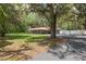 Expansive lot with mature trees surrounding a ranch-style house with red metal roof at 4010 Sw 7Th Avenue Rd, Ocala, FL 34471