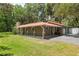Ranch-style house with well maintained lawn and mature landscaping. Features a red metal roof at 4010 Sw 7Th Avenue Rd, Ocala, FL 34471