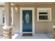 Close-up of the blue front door with decorative glass, sidelights, and stone-accented columns at 4010 Sw 7Th Avenue Rd, Ocala, FL 34471