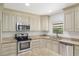 Close-up of the sun-lit kitchen featuring stainless steel appliances and custom cabinets at 4010 Sw 7Th Avenue Rd, Ocala, FL 34471