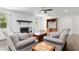 Bright living room with a white brick fireplace, hardwood floors, and modern ceiling fan at 4010 Sw 7Th Avenue Rd, Ocala, FL 34471