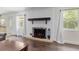 Cozy living room featuring a decorative fireplace, hardwood floors, and sun-lit windows at 4010 Sw 7Th Avenue Rd, Ocala, FL 34471