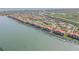 Wide aerial view showing waterfront residences with boat docks along the green waterway at 420 Bouchelle Dr # 204, New Smyrna Beach, FL 32169