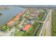 High aerial view of community featuring residences, tennis courts, a marina, and nearby waterway at 420 Bouchelle Dr # 204, New Smyrna Beach, FL 32169