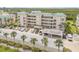 Exterior of condos with parking and tropical landscaping near a highway at 420 Bouchelle Dr # 204, New Smyrna Beach, FL 32169