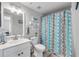 Cozy bathroom with patterned shower curtain, neutral colors, and wood look floors at 420 Bouchelle Dr # 204, New Smyrna Beach, FL 32169