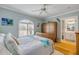 Comfortable bedroom featuring wood bed frame, hardwood floors, and views of a bathroom at 420 Bouchelle Dr # 204, New Smyrna Beach, FL 32169