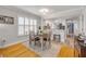 Cozy dining area showcases a wood table, white shutters, and an open view to the kitchen, all illuminated by warm lighting at 420 Bouchelle Dr # 204, New Smyrna Beach, FL 32169