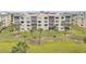 Condo building exterior with lush landscaping and palm tree accents at 420 Bouchelle Dr # 204, New Smyrna Beach, FL 32169