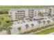 Condo building exterior with palm trees and parking spaces at 420 Bouchelle Dr # 204, New Smyrna Beach, FL 32169