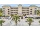 Condo building exterior with lush palm trees and convenient parking spaces at 420 Bouchelle Dr # 204, New Smyrna Beach, FL 32169