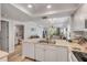 Open kitchen with white cabinetry, stainless steel sink, and a view into the bathroom and living area at 420 Bouchelle Dr # 204, New Smyrna Beach, FL 32169