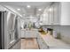Spacious kitchen featuring stainless steel refrigerator, white cabinetry, and an open layout to the living area at 420 Bouchelle Dr # 204, New Smyrna Beach, FL 32169