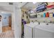 Organized laundry room with modern white washer and dryer, shelving, and easy access from the hallway at 420 Bouchelle Dr # 204, New Smyrna Beach, FL 32169