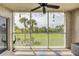 Relaxing screened in patio overlooking a green lawn with palm trees and sunny skies at 420 Bouchelle Dr # 204, New Smyrna Beach, FL 32169