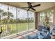 Relaxing screened-in patio with seating, a ceiling fan, and beautiful views of the lush green landscape at 420 Bouchelle Dr # 204, New Smyrna Beach, FL 32169