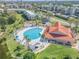 Aerial view of a pool and lounge area with palm trees around a beautiful resort and lawn at 420 Bouchelle Dr # 204, New Smyrna Beach, FL 32169