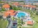An aerial view showcases the pool and lounge area with palm trees around a lovely resort at 420 Bouchelle Dr # 204, New Smyrna Beach, FL 32169