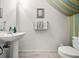 Clean, well-lit half bathroom with a pedestal sink, decorative accents, and neutral tiling at 4412 Sw 49Th Ave, Ocala, FL 34474