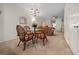 Cozy dining area with a glass top table, woven chairs, and chandelier lighting, adjacent to the living area at 4412 Sw 49Th Ave, Ocala, FL 34474