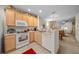 Bright kitchen featuring white appliances, light wood cabinets, and an open view to the dining and living areas at 4412 Sw 49Th Ave, Ocala, FL 34474