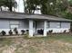 Inviting covered front porch with stylish tile flooring and a cozy seating area at 5549 Nw 64Th St, Ocala, FL 34482