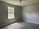 This bedroom features modern gray wood-look tile flooring, a ceiling fan, and a window for natural light at 5787 Nw 58Th Ter, Ocala, FL 34482