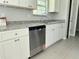 Well-equipped kitchen boasts stainless steel dishwasher, granite countertops and pristine white cabinetry at 5787 Nw 58Th Ter, Ocala, FL 34482