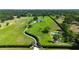 Expansive aerial view of estate home with a long driveway, lush green lawn, pond and mature trees at 601 Se 80Th St, Ocala, FL 34480