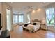 Bright main bedroom with hardwood floors, ceiling fan, and sitting area with many windows at 601 Se 80Th St, Ocala, FL 34480