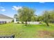 Spacious backyard featuring a lush lawn, mature trees, and a screened-in patio at 6651 Sw 93Rd Ct, Ocala, FL 34481