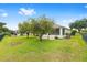 Well-kept backyard featuring lush greenery, mature trees, and a screened-in lanai at 6651 Sw 93Rd Ct, Ocala, FL 34481