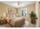 Cozy bedroom featuring a ceiling fan, plush bedding, and bright natural light at 6651 Sw 93Rd Ct, Ocala, FL 34481