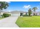 Beautiful single-story home with green lawn, palm trees and a two-car garage at 6651 Sw 93Rd Ct, Ocala, FL 34481